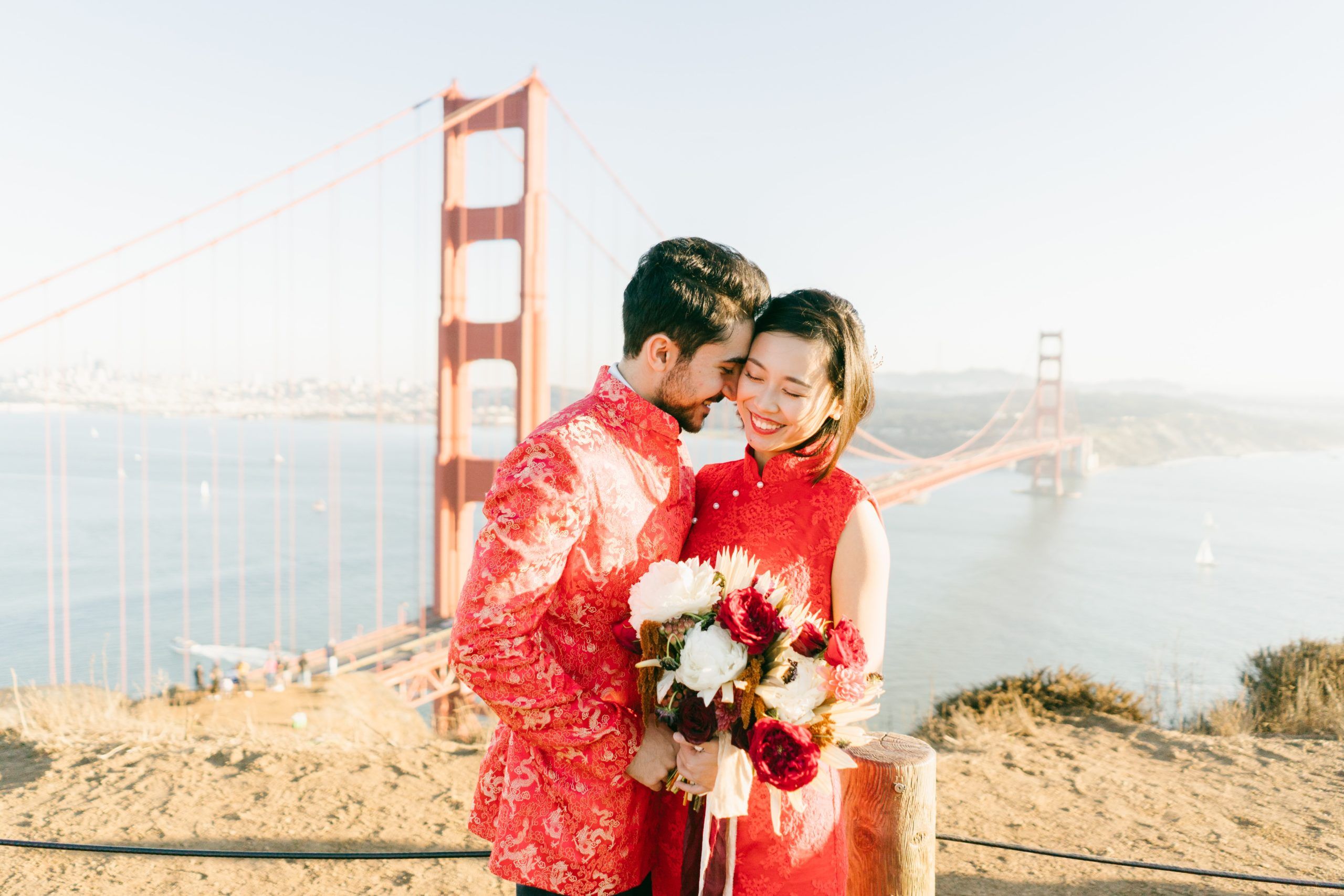 Bride and groom in red holding bouquet of flowers | Spark Experiences microwedding planners in the Bay Area