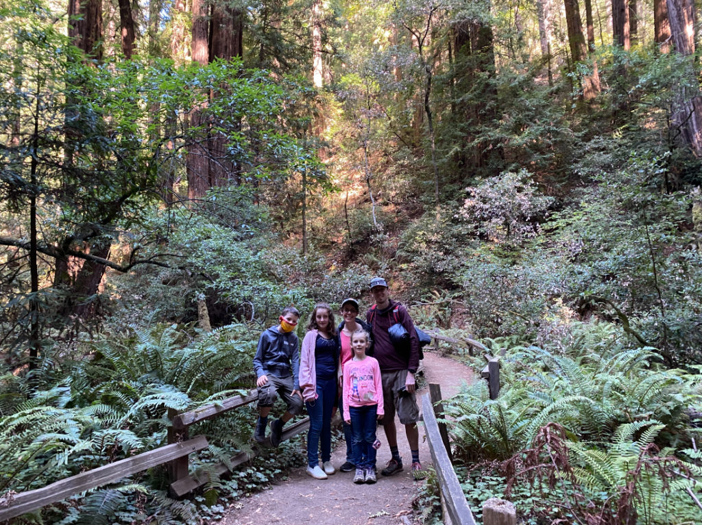 Family posing in Muir Woods on a day tour with Spark Experiences
