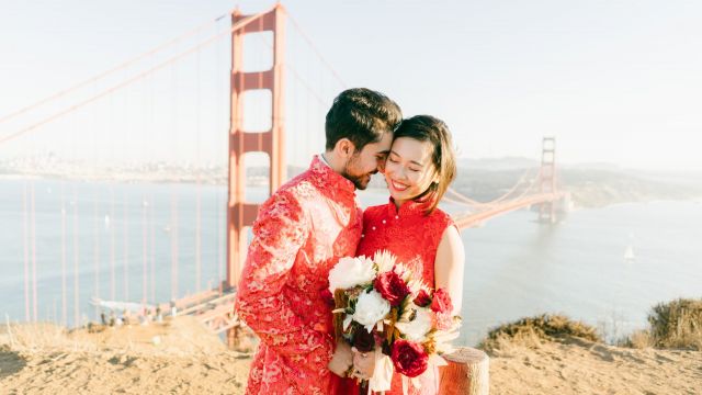 Bride and groom in red holding bouquet of flowers | Spark Experiences microwedding planners in the Bay Area
